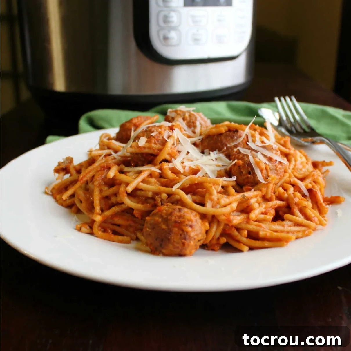 Make a dinnertime favorite even quicker and easier! The Instant Pot is a great way to make creamy spaghetti and meatballs with minimal dishes and effort. A generous serving of creamy spaghetti and meatballs on a plate, with an Instant Pot visible in the background, signaling an easy, one-pot meal.