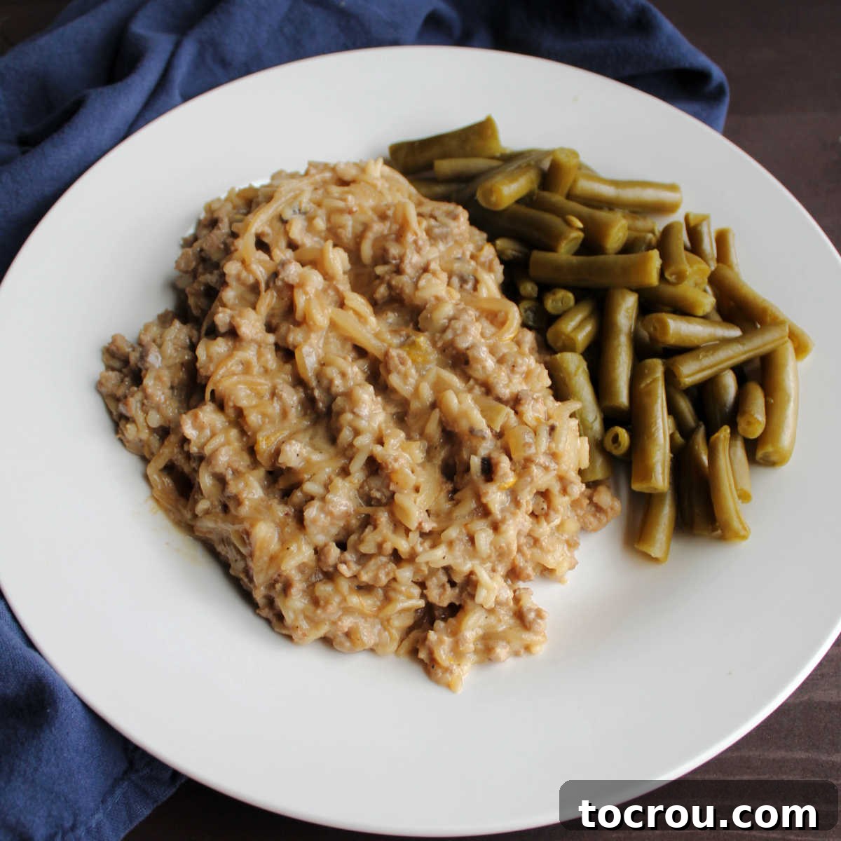 A serving of creamy ground pork and mushroom rice, a delightful American chop suey, garnished with fresh green beans, ready to be enjoyed as a quick and easy comfort food meal.