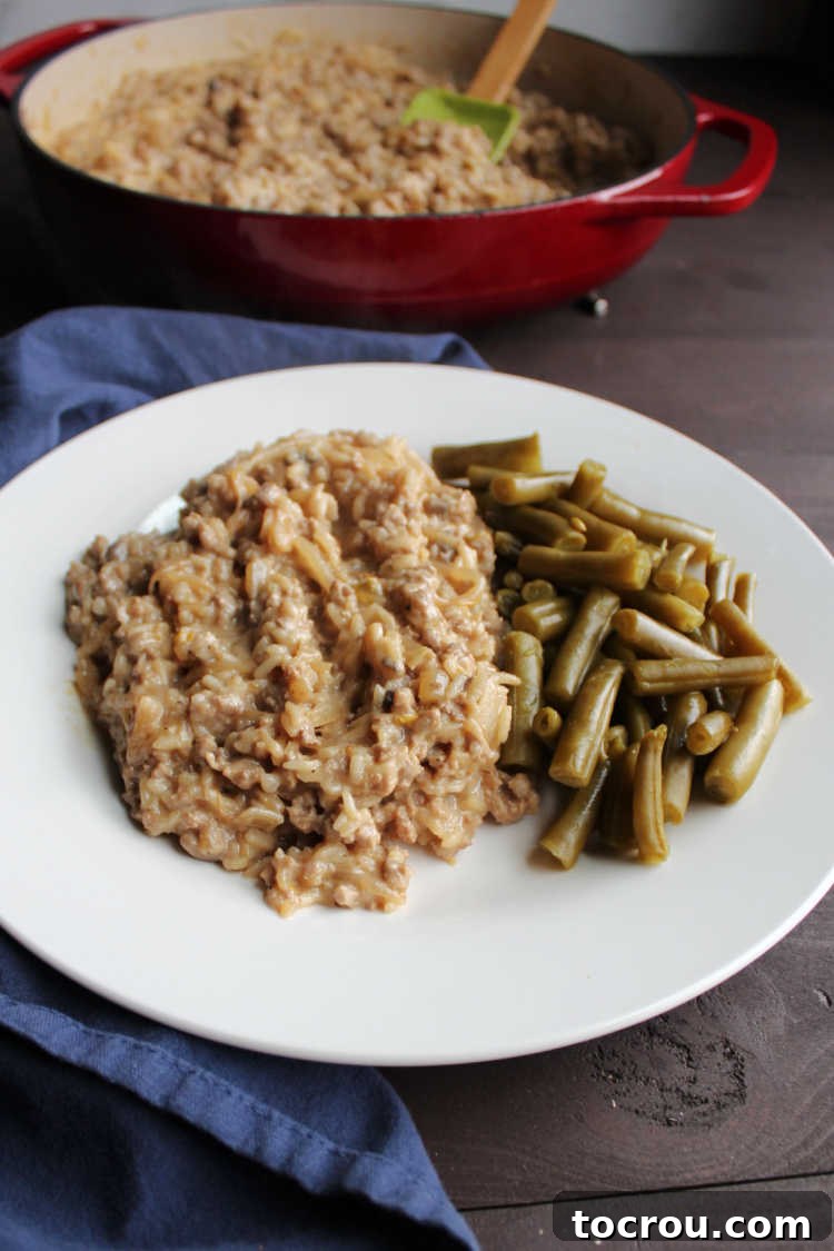 A perfectly plated serving of creamy pork chop suey with a side of bright green beans, emphasizing its readiness as a quick and satisfying meal.