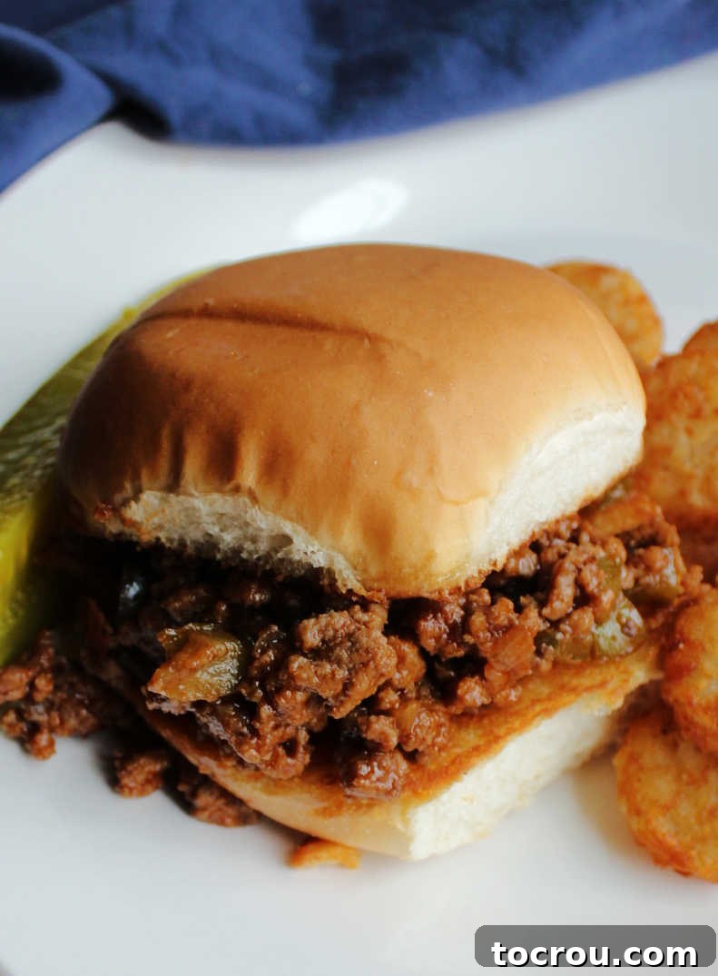 Sloppy Joe Close Up Close-up view of the rich, tomato-based sloppy joe mixture generously piled onto a soft, toasted bun, highlighting the delicious texture and sauce.