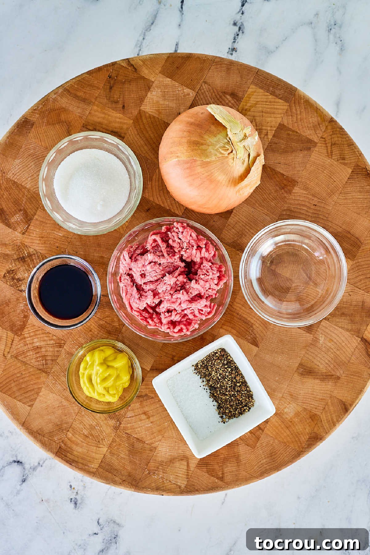 Ingredients including ground beef, onion, salt, pepper, soy sauce, mustard, and water ready to be made into homemade maid rite sandwiches.