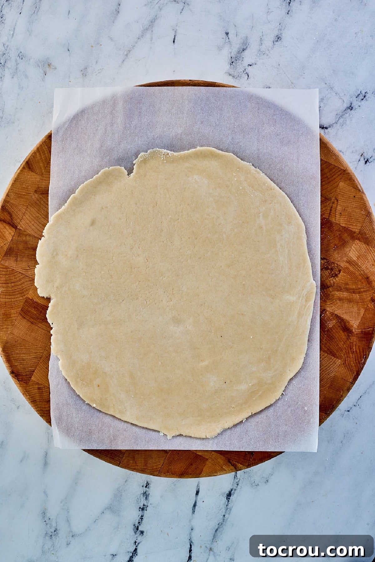 Perfectly rolled out pie crust pastry, stretched into an even, thin circular shape, ready to be transferred to a pie pan.
