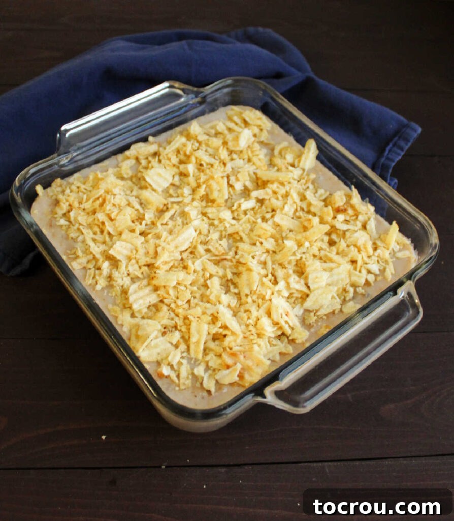 Mimi's Signature Tuna Bake 5 A freshly baked creamy tuna casserole in a glass baking dish, topped with golden-brown crushed potato chips, ready to be served.