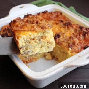 Golden Waffle and Sausage Breakfast Bake 2 lifting square piece of egg, sausage, cheese and waffle casserole being lifted out of the baking dish.