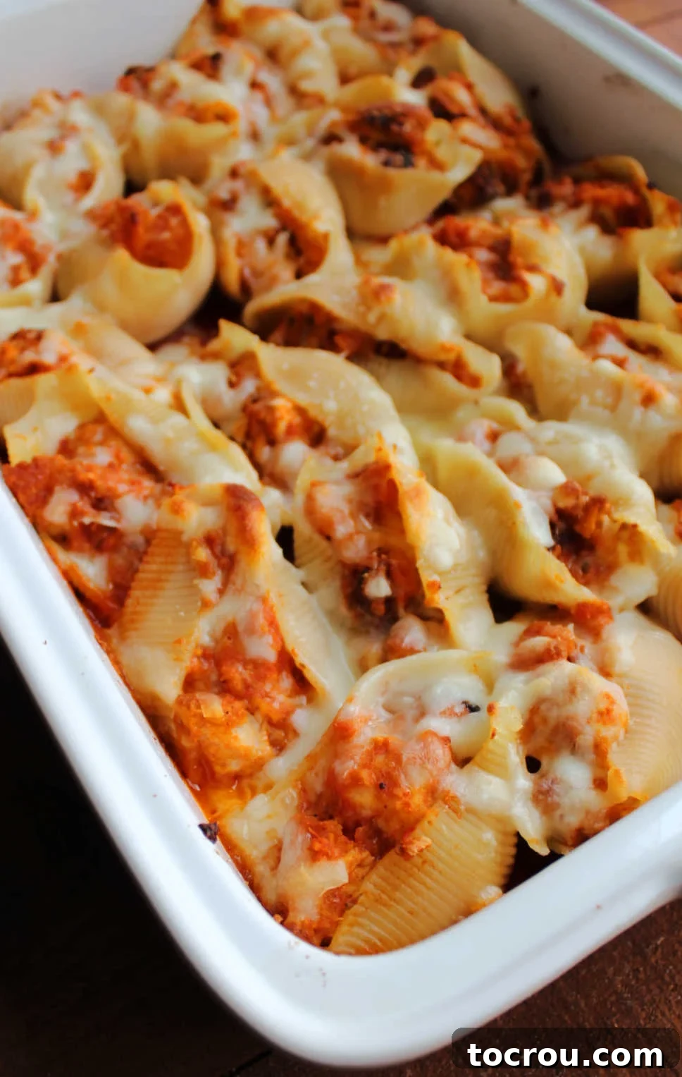Pan of freshly baked chicken Parmesan baked shells, golden and bubbly.
