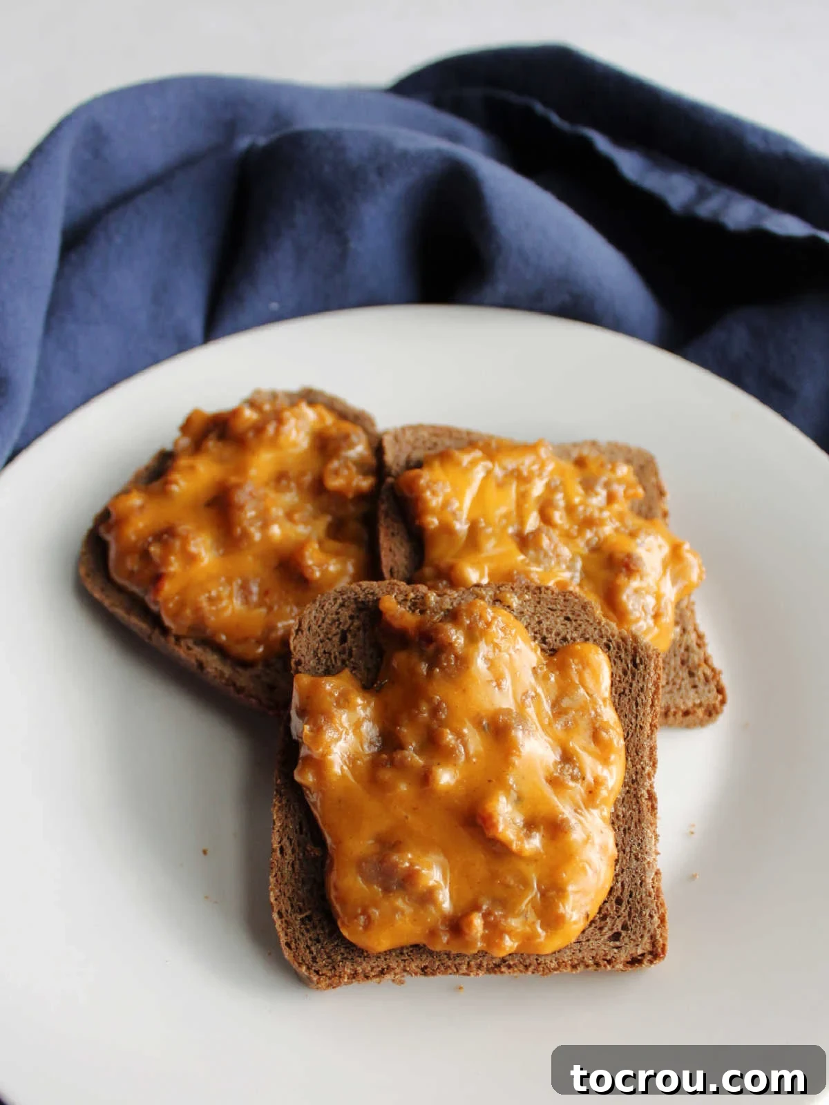 Rye Pizza Party Bites 4 Close-up shot of freshly baked party ryes, showing the melty cheese and sausage topping.