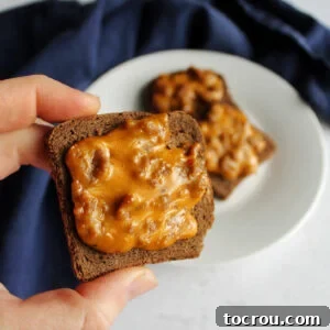 Hand holding pizza flavored party rye appetizer ready to eat.