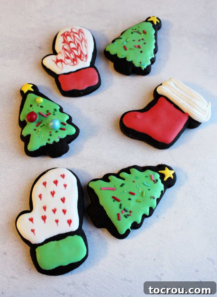 dark chocolate cookies cut into Christmas shapes and decorated with royal icing.