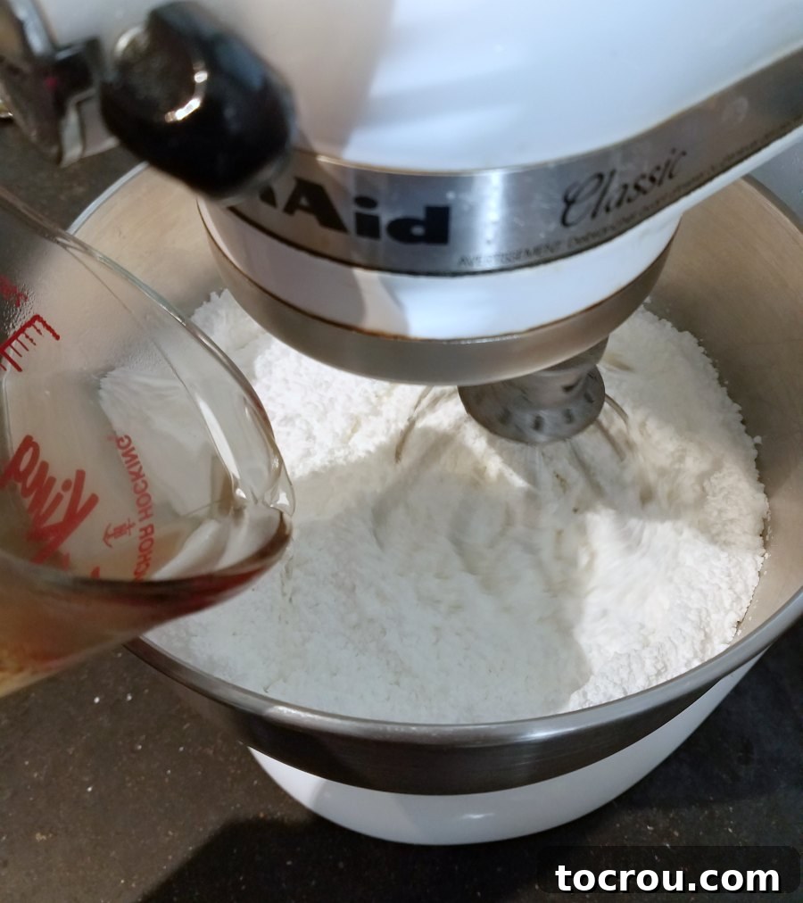 pouring warm water into sugar and meringue powder mixture.