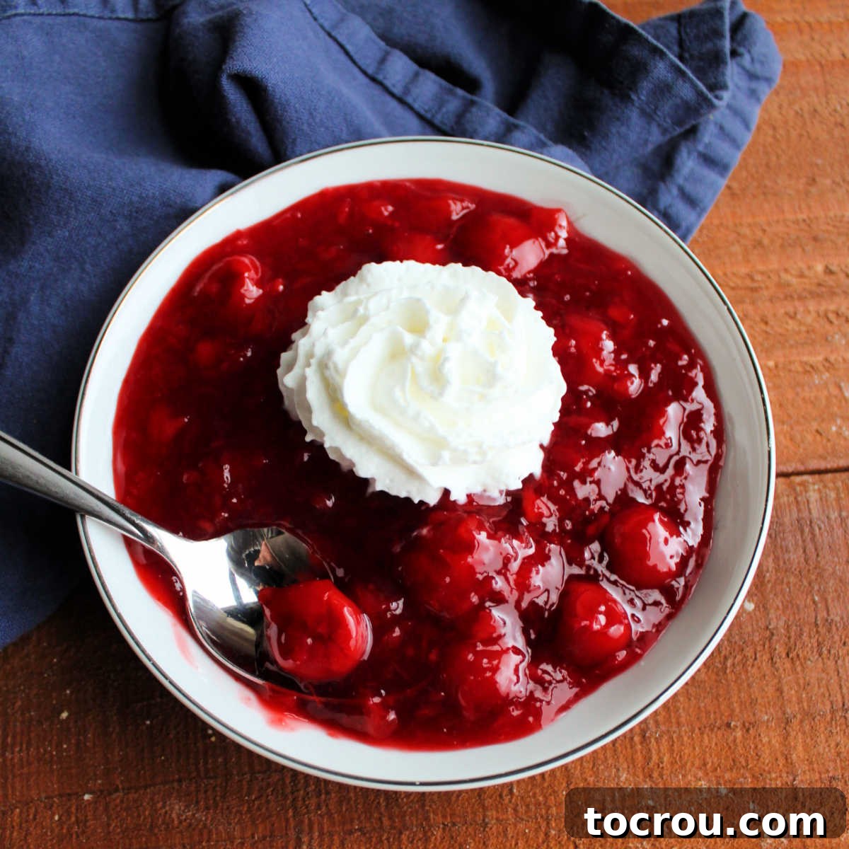 Tropical Cherry Fluff Salad 2 Bowl of cherry pineapple jello salad topped generously with whipped cream and a cherry garnish