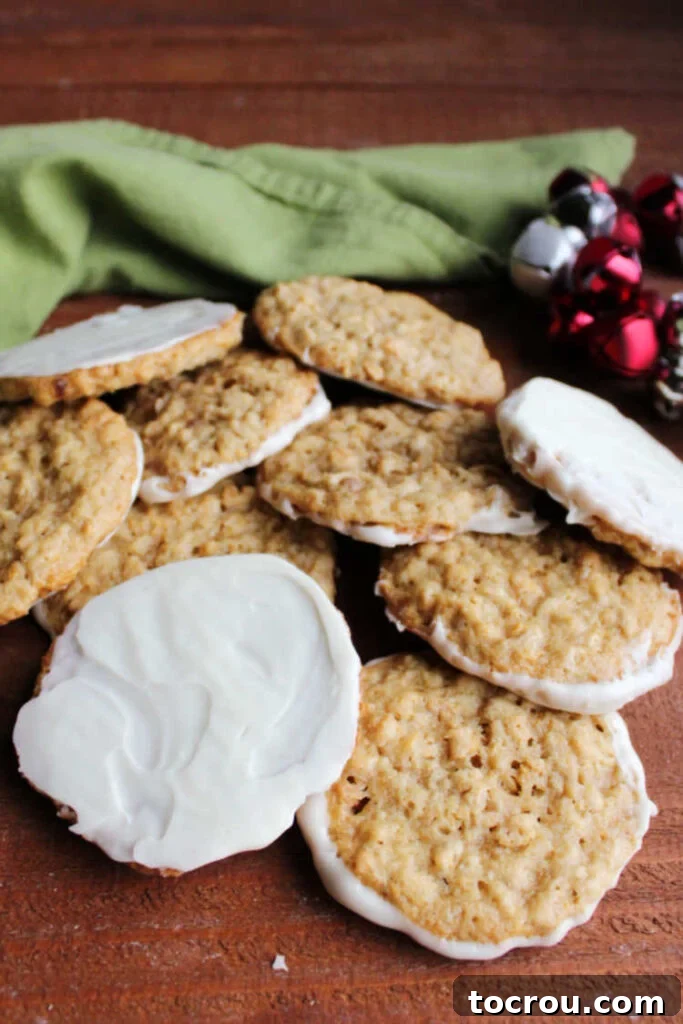 A tempting pile of white chocolate-dipped Frostbite cookies, artfully arranged with festive jingle bells in the background, signaling holiday cheer.