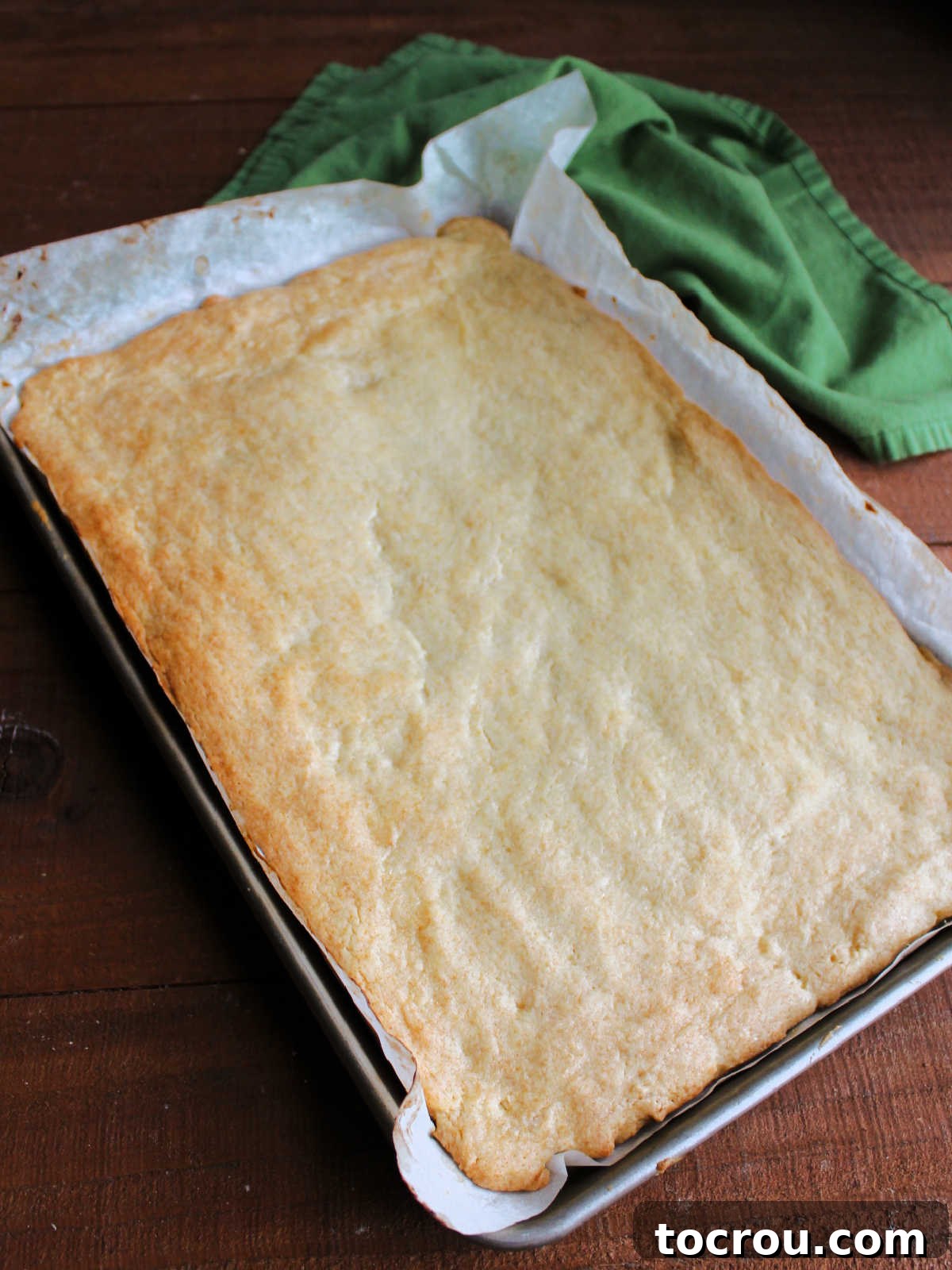 Freshly baked sugar cookie bars with a lightly golden-brown edge, cooling in the pan.