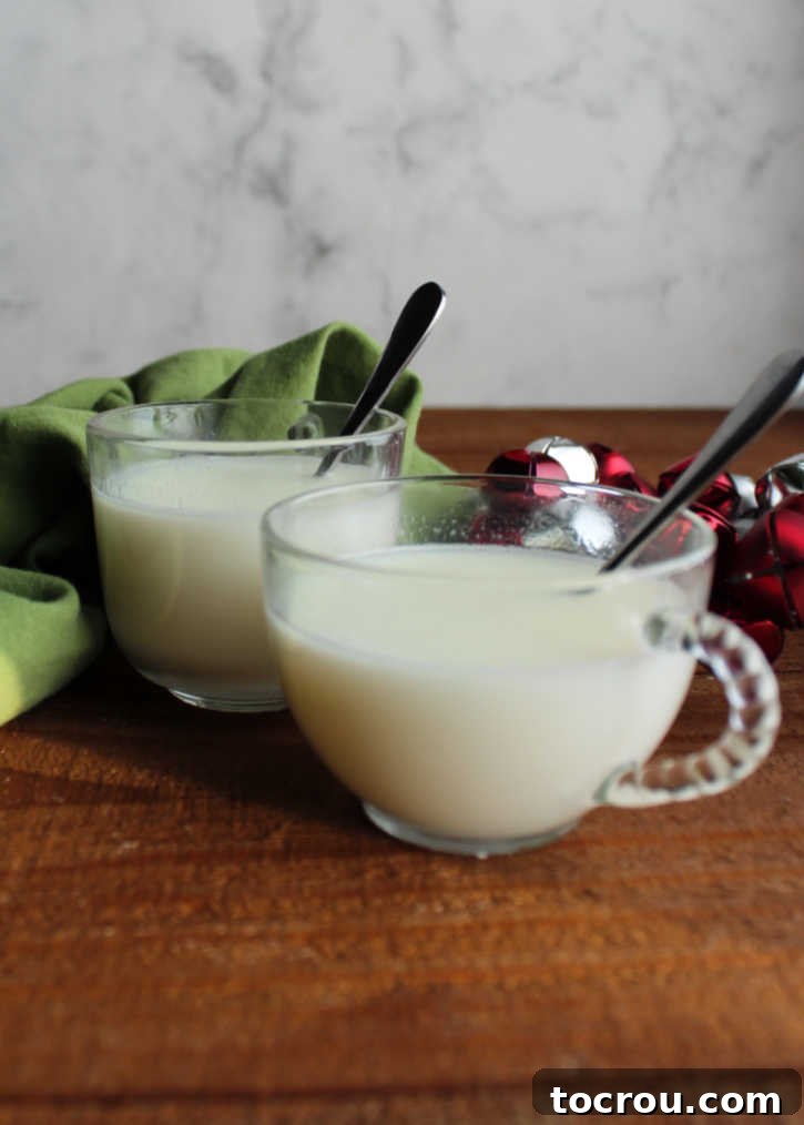 Two clear glass mugs filled with steaming homemade white hot chocolate, showcasing the inviting warmth and creamy texture of the beverage.