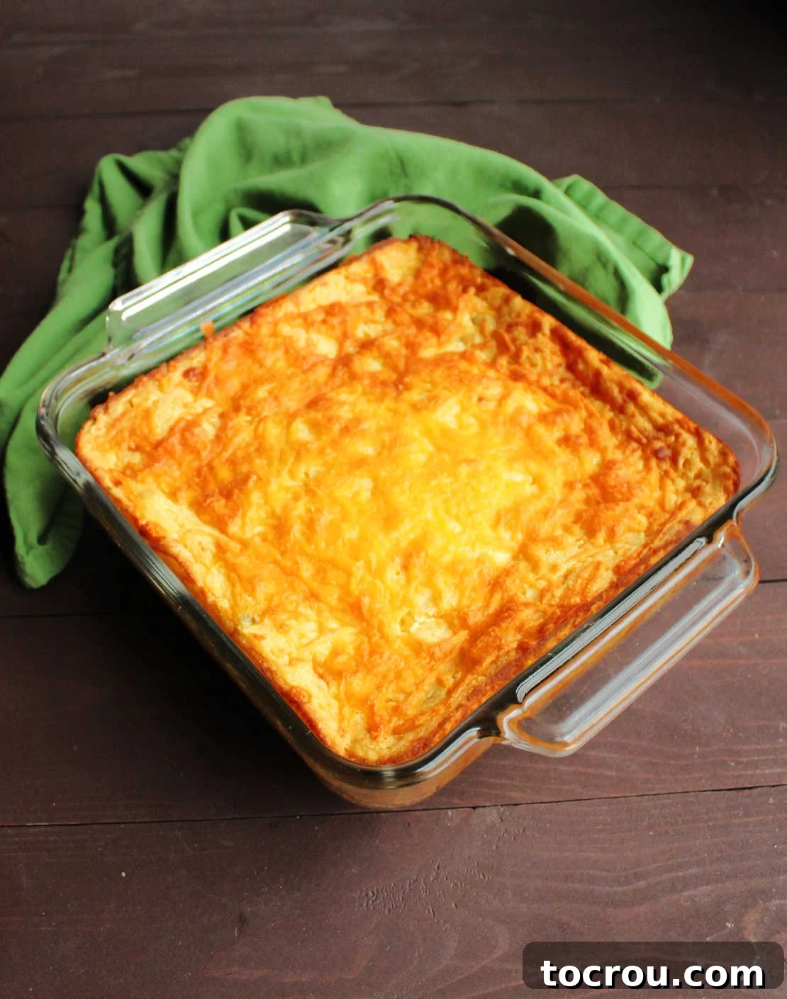 Freshly Baked Corn Casserole Pan of freshly baked green chile corn casserole with melted cheddar cheese on top.