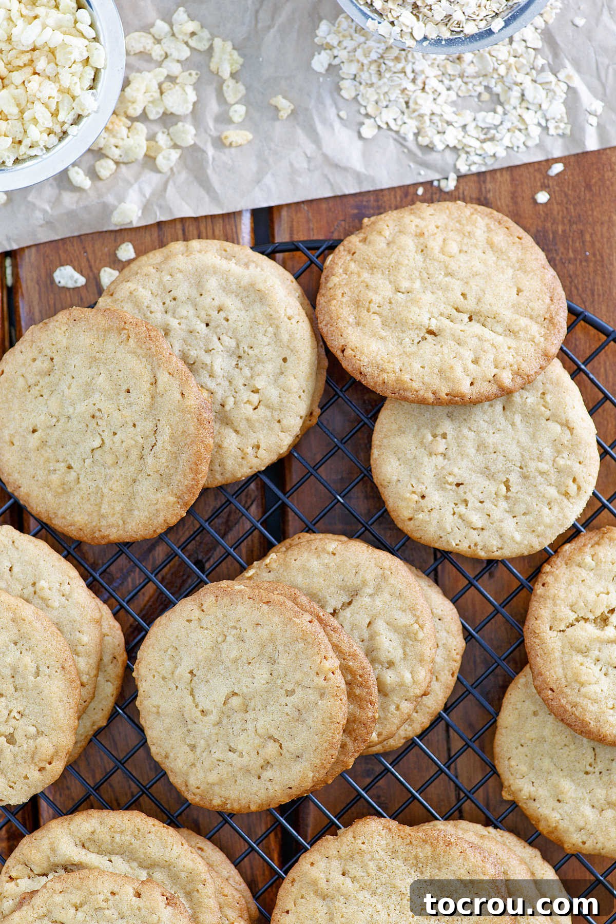 looking down on freshly baked 7 cup cookies with bowls of oatmeal and rice krispies nearby.