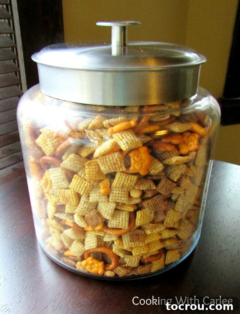 A classic and crunchy Chex mix, perfect for sharing or a quick snack. A charming glass jar brimming with crunchy Chex mix, showcasing a vibrant assortment of cereals, savory cheese crackers, and roasted peanuts.