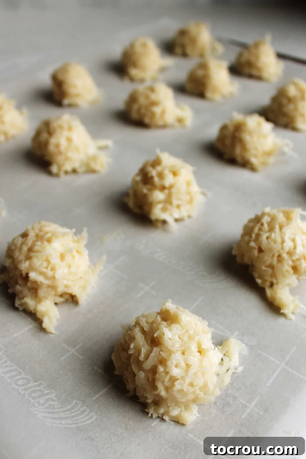 Irresistible Condensed Milk Coconut Bites 4 Scoops of condensed milk coconut macaroons ready to be baked.
