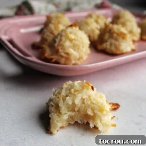 Chewy coconut macaroon with a bite missing showing the soft center.
