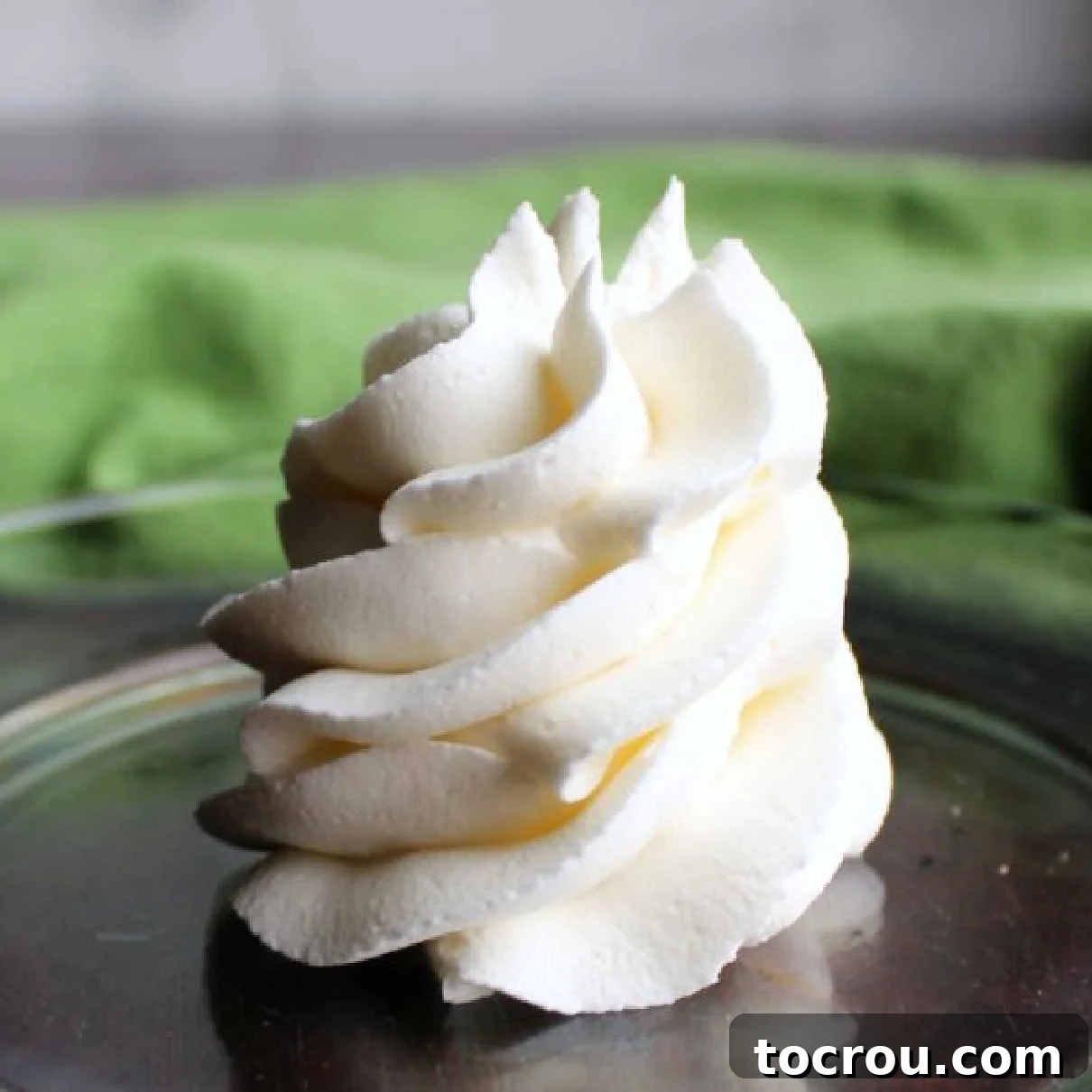 A beautiful swirl of pristine white classic American buttercream artfully plated, ready to adorn your favorite desserts.