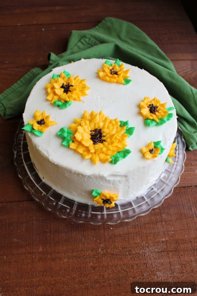 A beautifully decorated layer cake topped with vibrant 3D frosting sunflowers, showcasing the piping capabilities of buttercream.