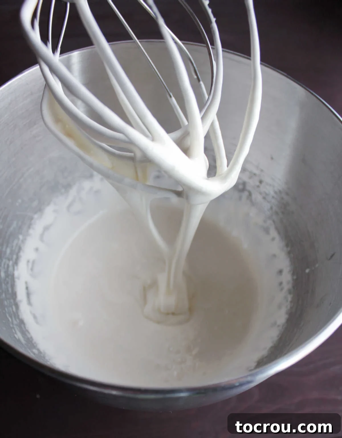 Aerated Sweetened Condensed Milk Aerated white whipped sweetened condensed milk on beater.