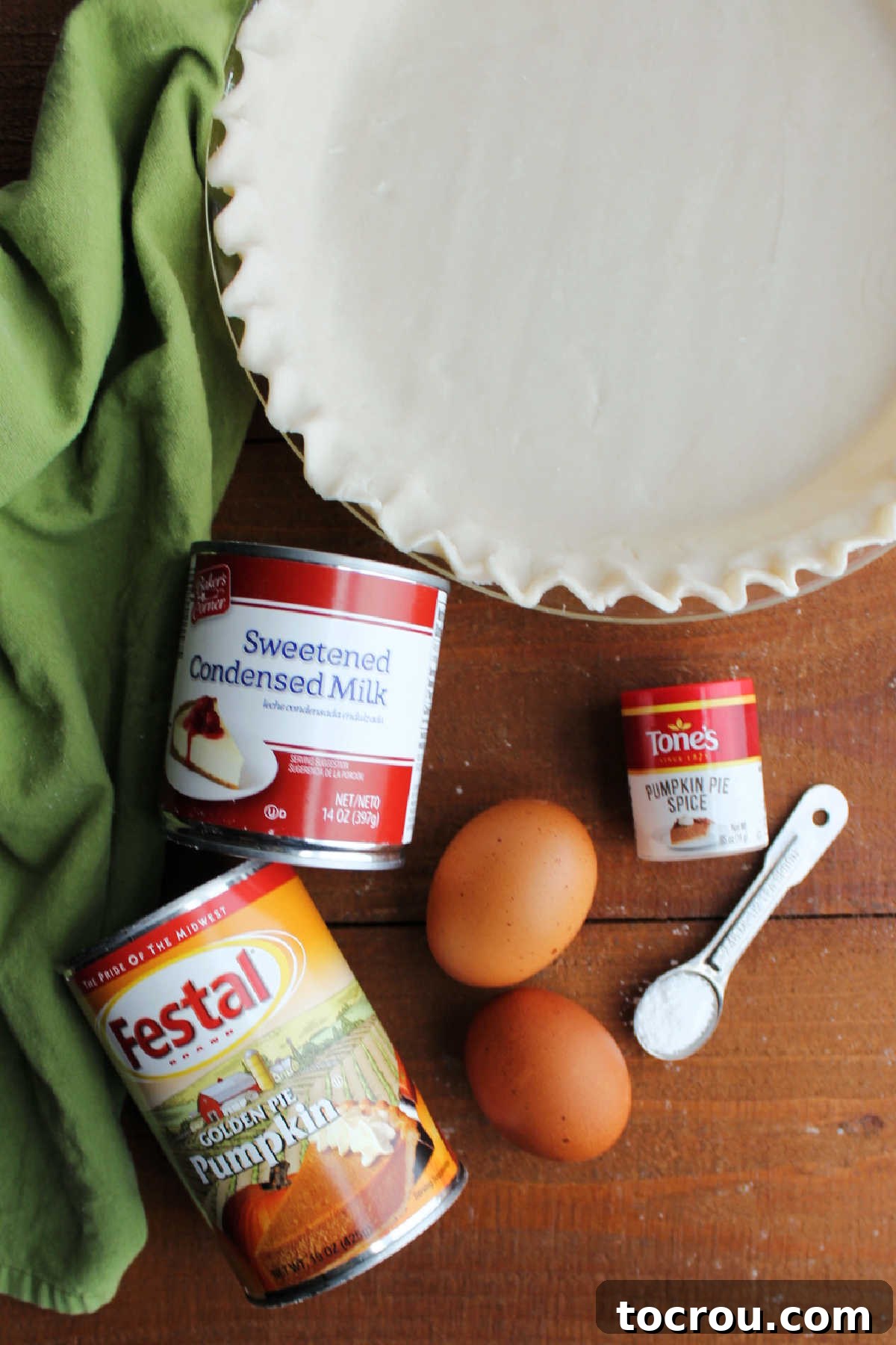Pumpkin Pie Ingredients: Simplicity at its Best The essential ingredients for a luscious pumpkin pie: canned pumpkin puree, a can of sweetened condensed milk, fresh eggs, and a blend of aromatic spices, all laid out beside an uncooked pie crust.