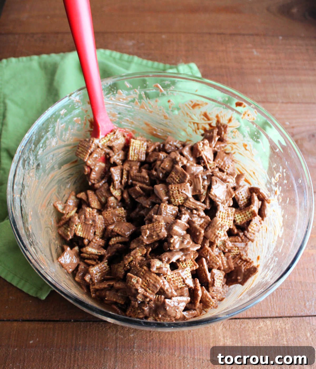 Bowl of Chex cereal coated in melted chocolate and peanut butter, ready to go in the bag of powdered sugar.