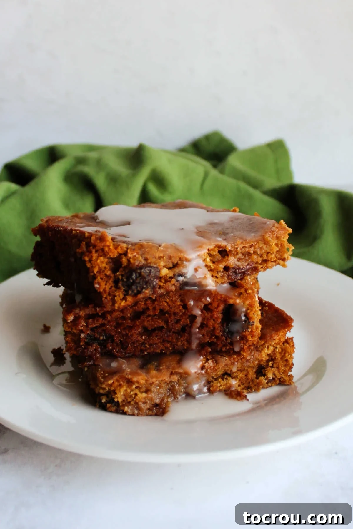 Poor Man's Cake with Glaze A generous pile of Poor Man's Cake pieces, artfully arranged, with a simple powdered sugar glaze drizzling down their sides.
