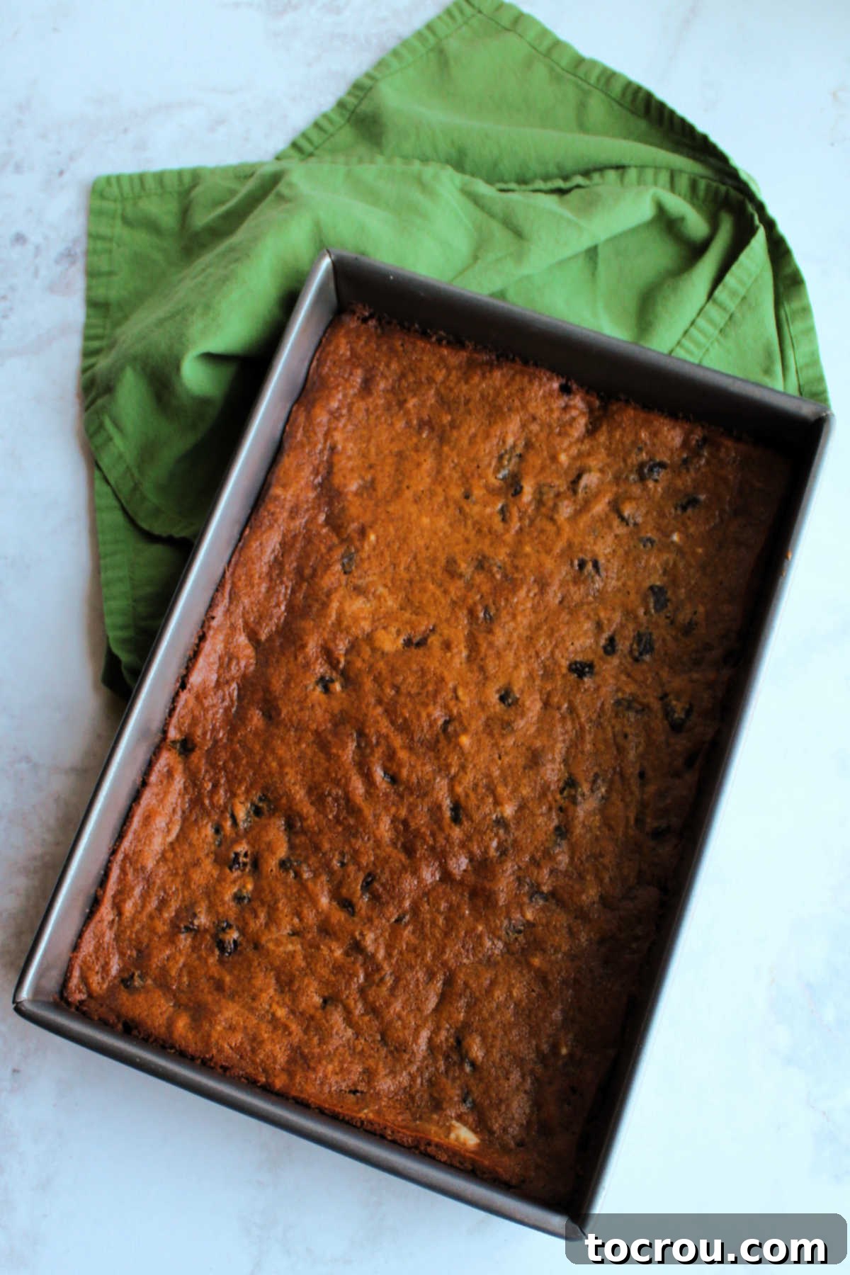 Baked Poor Man's Cake A fresh-from-the-oven pan filled with warm, golden-brown Poor Man's Raisin Cake, ready for cooling and serving.