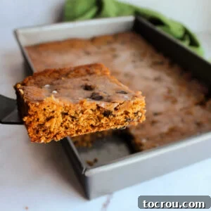 Lifting the first piece of moist, spiced raisin poor man's cake out of a baking pan.