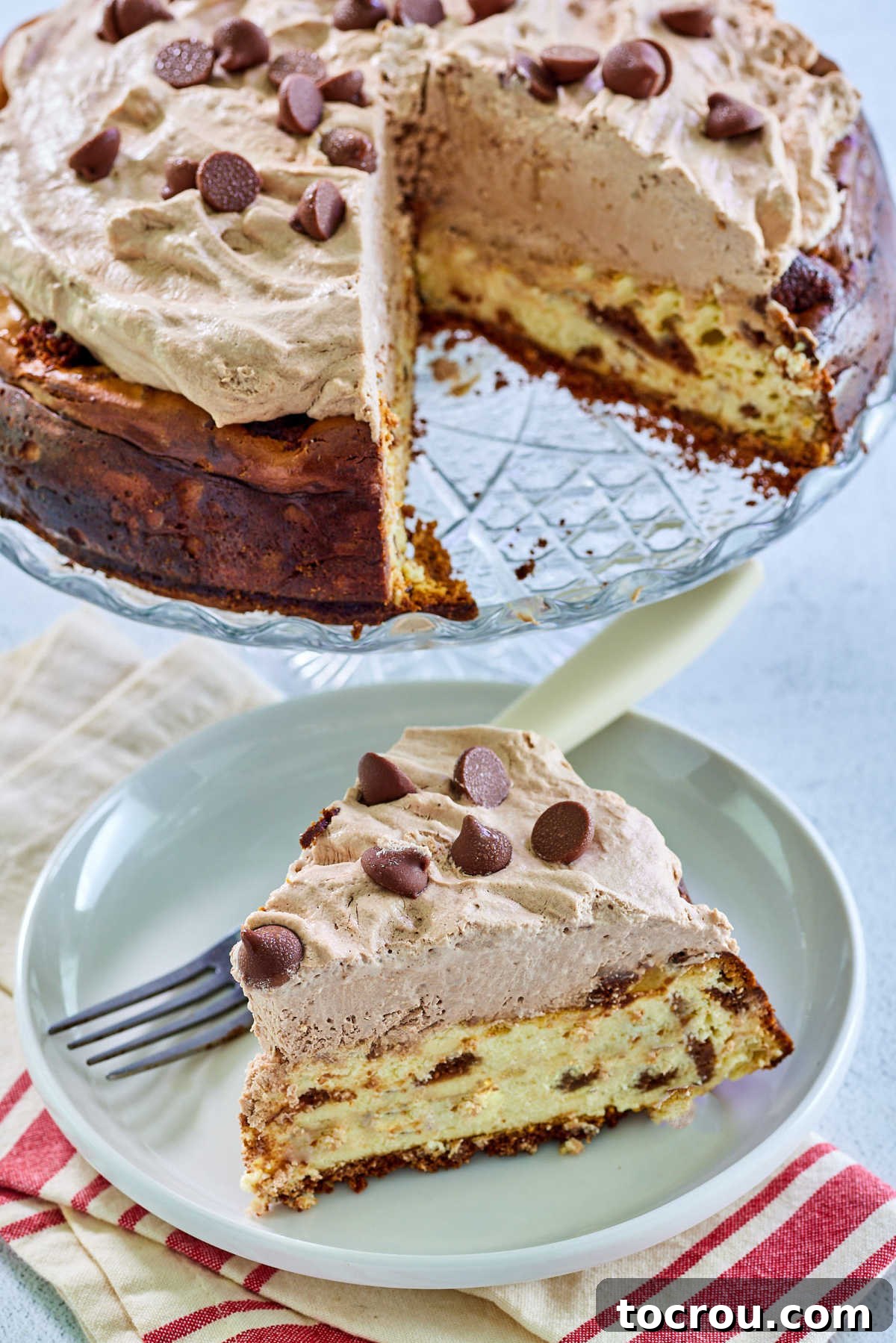 Fluffy whipped cream spiked with coffee and chocolate. It is a great frosting for cakes, topping for cheesecakes or would be great floating on your cup of coffee. Slice of brownie chunk cheesecake topped with mocha whipped cream on dessert plate with remaining cheesecake on glass cake stand in the background.