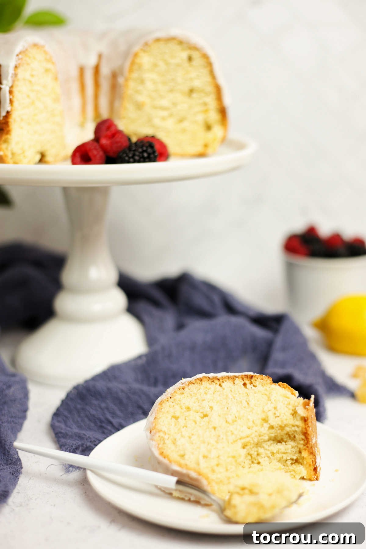 Sun-Kissed Lemon Bundt with Ginger Drizzle 6 A forkful of moist lemon Bundt cake, glistening with glaze, ready to be eaten.