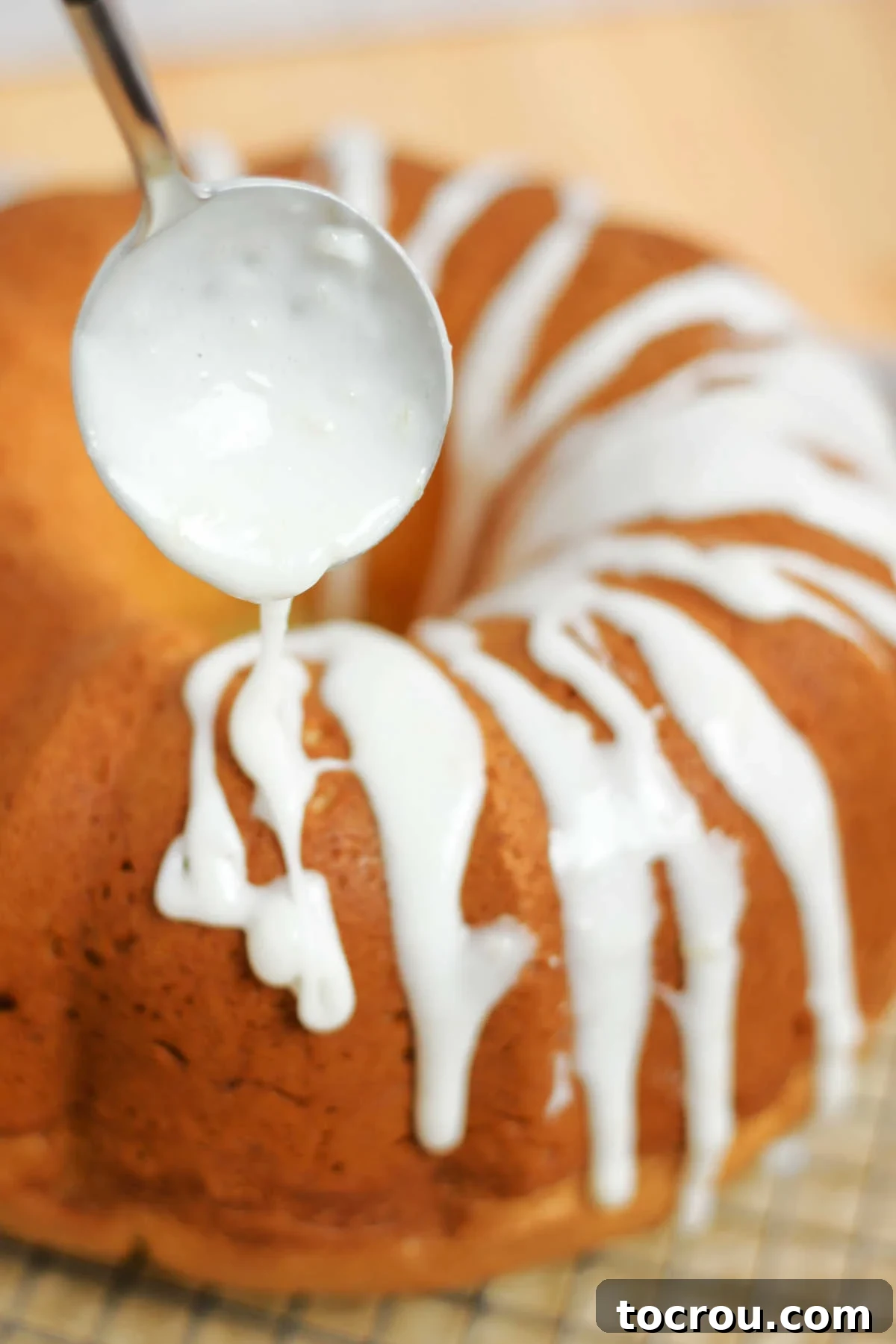 Sun-Kissed Lemon Bundt with Ginger Drizzle 8 Drizzling a thick, white lemon ginger powdered sugar glaze over a cooled Bundt cake.