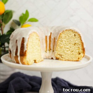 Sun-Kissed Lemon Bundt with Ginger Drizzle 10 2/3 of lemon bundt cake with white glaze and soft yellow interior showing.