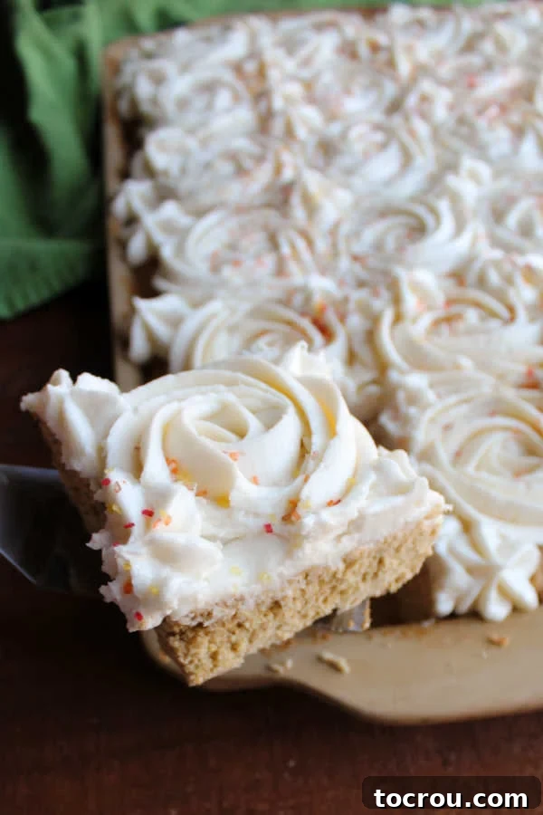 Freshly Baked Pumpkin Spice Cookie Bar A corner piece of pumpkin spice cookie bar being lifted gently out of the pan, showing its soft texture.