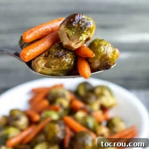 Spoonful of honey roasted brussels sprouts and carrots, ready to eat.