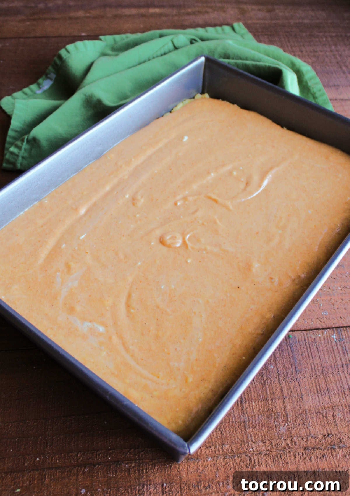 Ooey Gooey Pumpkin Butter Cake 8 A pan filled with the vibrant, creamy pumpkin gooey butter mixture, smoothed over the crust and perfectly prepared to be baked to a golden, gooey perfection.