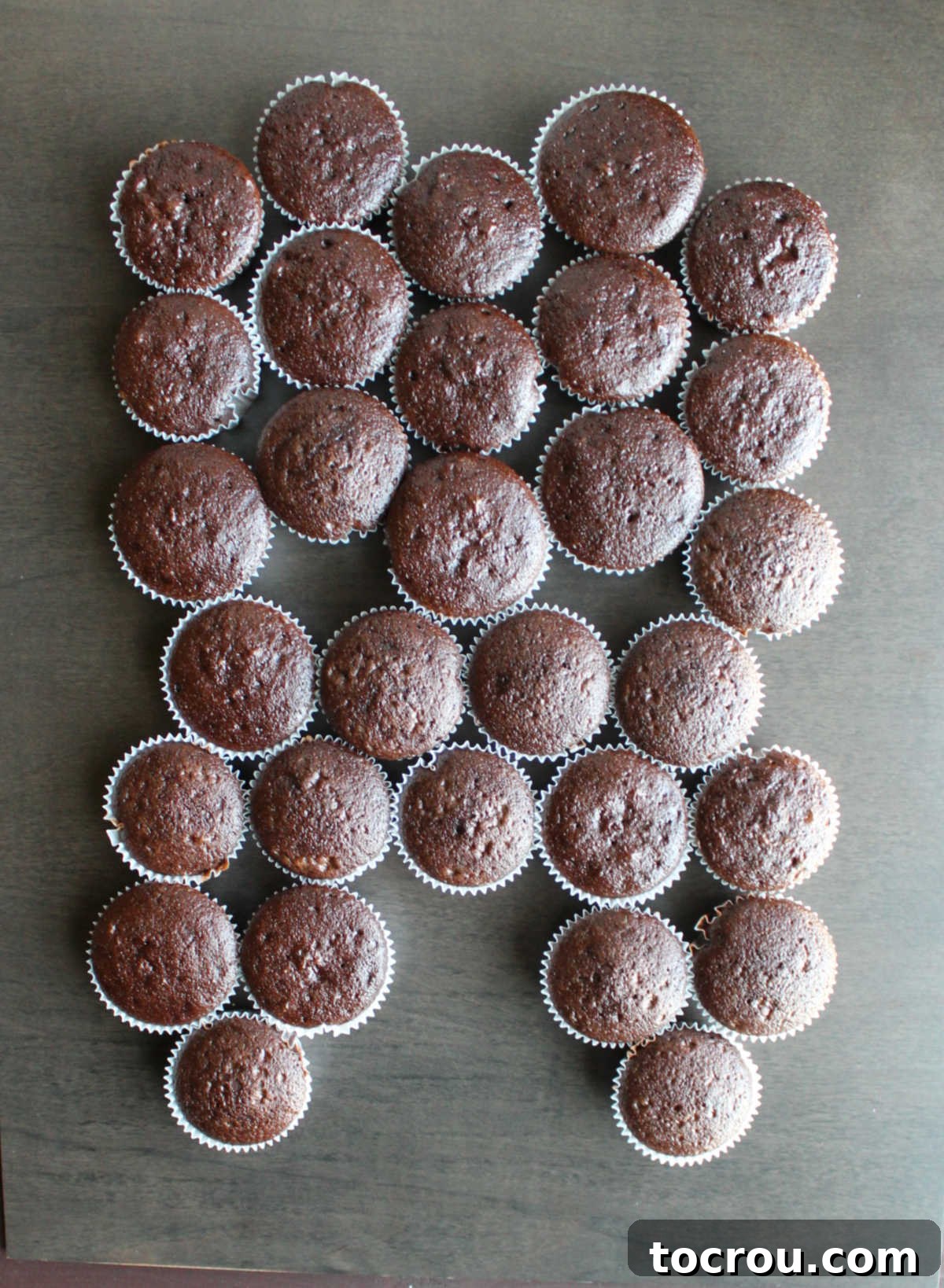 Chocolate cupcakes arranged in the pattern of a tooth on a large board.