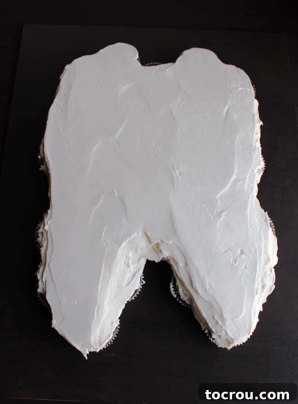 Close-up of the completed molar tooth-shaped cupcake pull-apart cake with 'Happy Birthday' and frosting toothbrushes piped on.