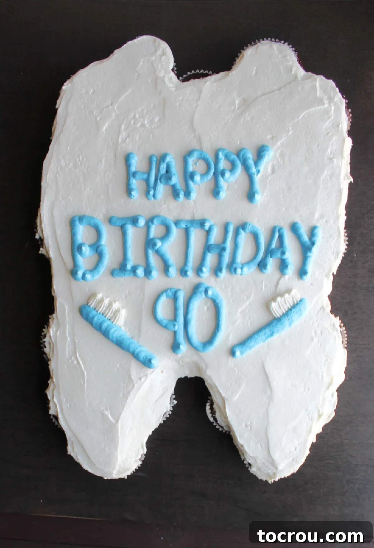 A beautifully decorated tooth-shaped pull-apart cupcake cake, ready for guests to enjoy.