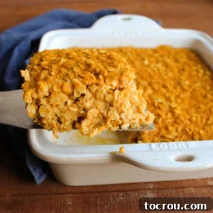 A close-up shot of a slice of pumpkin baked oatmeal being lifted out of the pan, showcasing its soft texture and rich color, ready to be enjoyed.