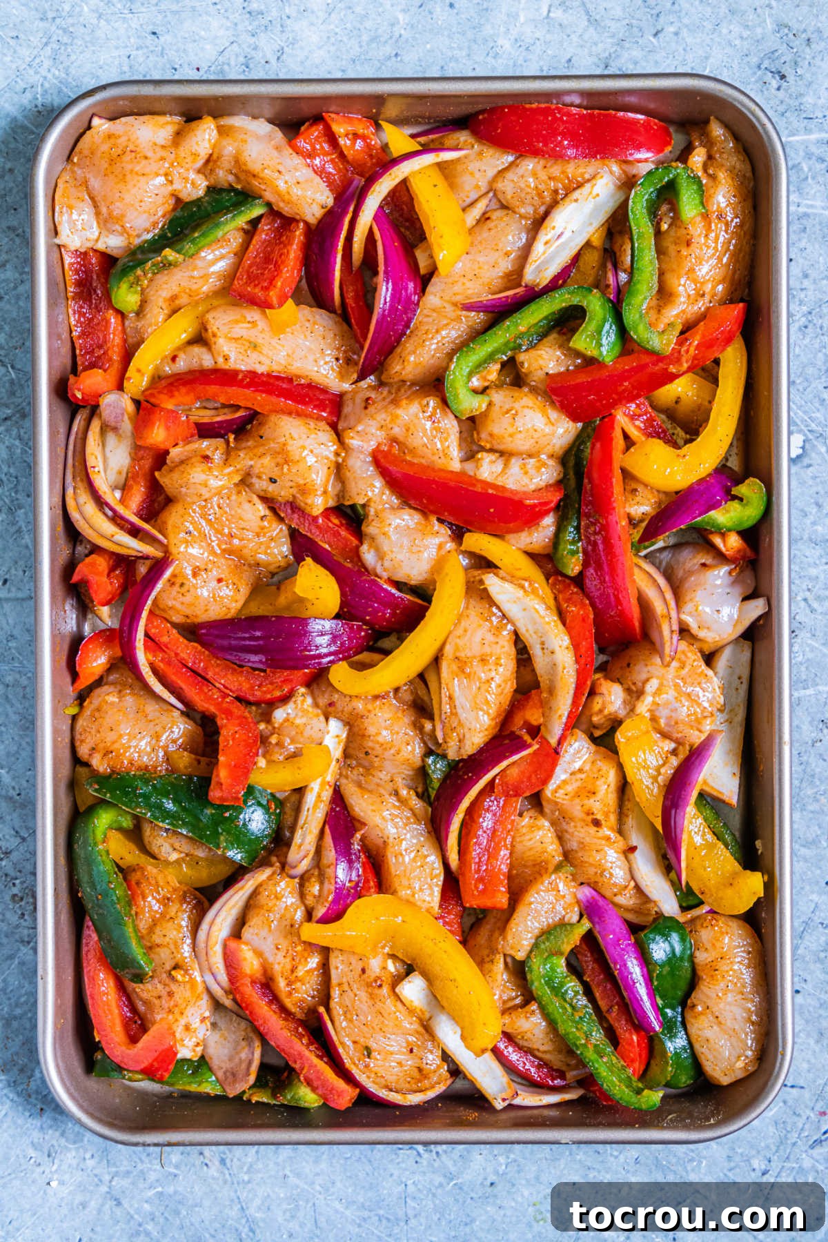 One-Pan Chicken Fajitas 6 chicken fajita ingredients tossed with oil and seasoning, ready to bake.
