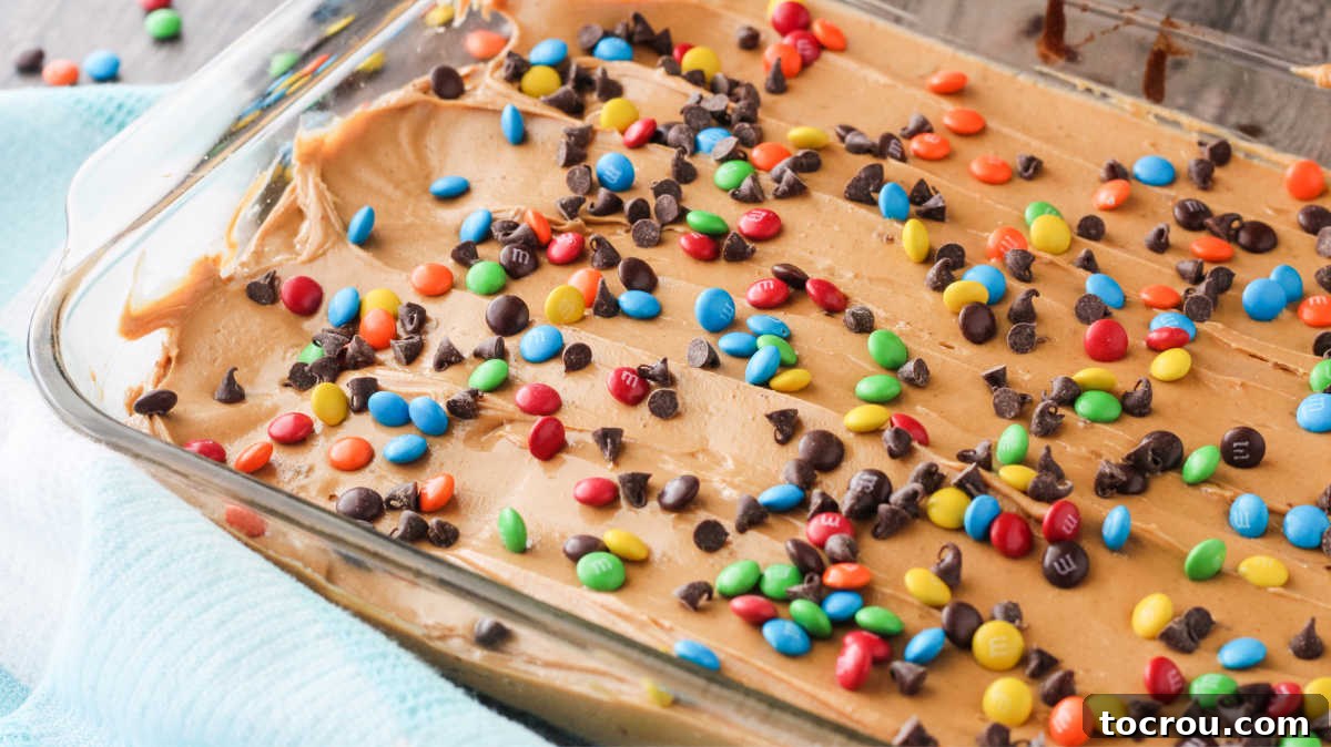 Triple Layer Peanut Butter Graham Brownies 4 Pan of brownies topped with peanut butter and candies.