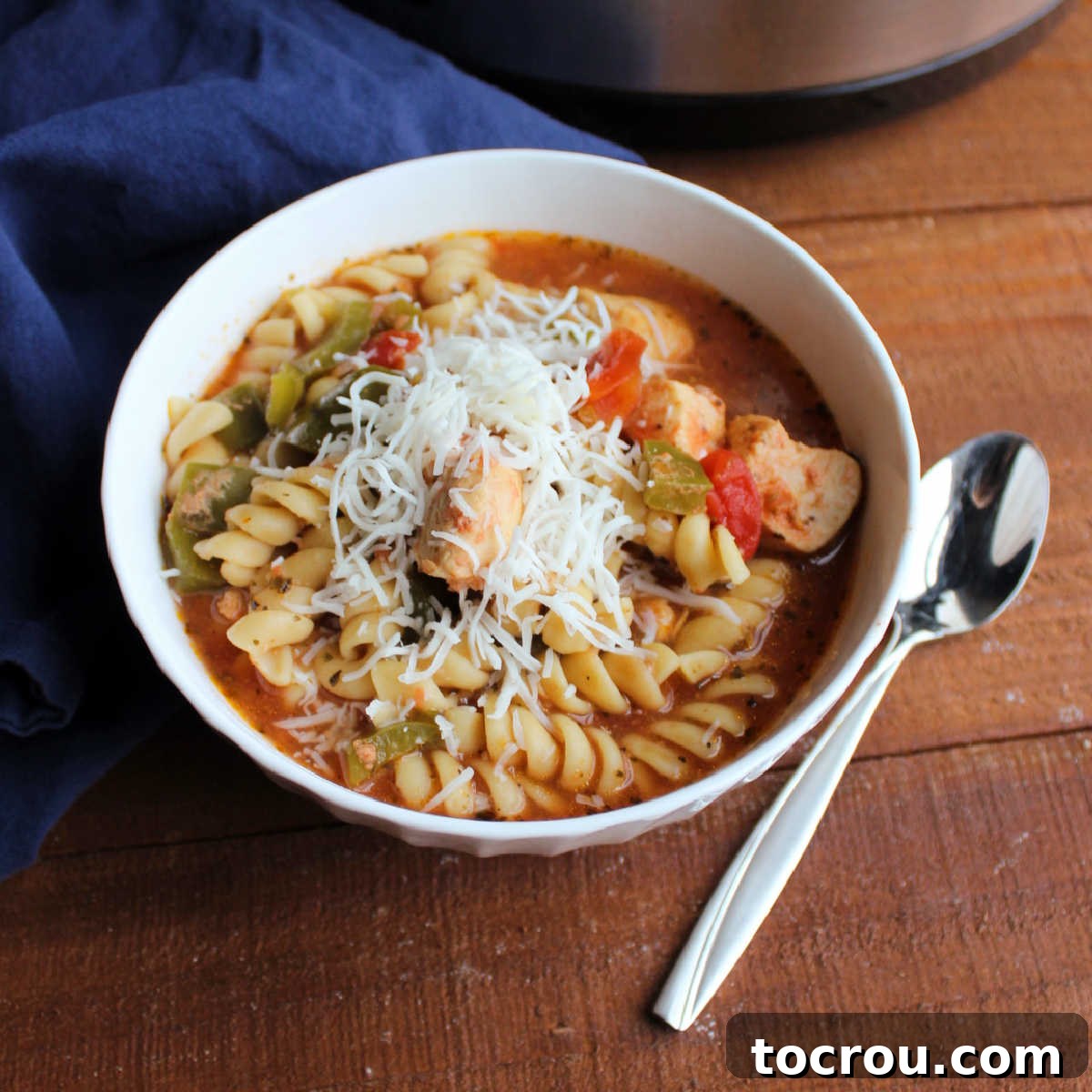 Hearty Italian Slow Cooker Chicken Tomato Soup A steaming bowl of Slow Cooker Tomato Chicken Soup, garnished with fresh herbs and shredded Parmesan cheese, ready to be enjoyed.