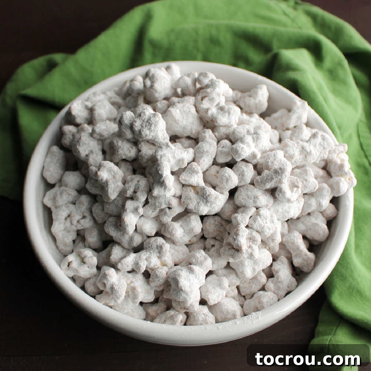 Puppy Chow Popcorn Delight Bowl of chocolate peanut butter puppy chow popcorn, ready to be enjoyed.