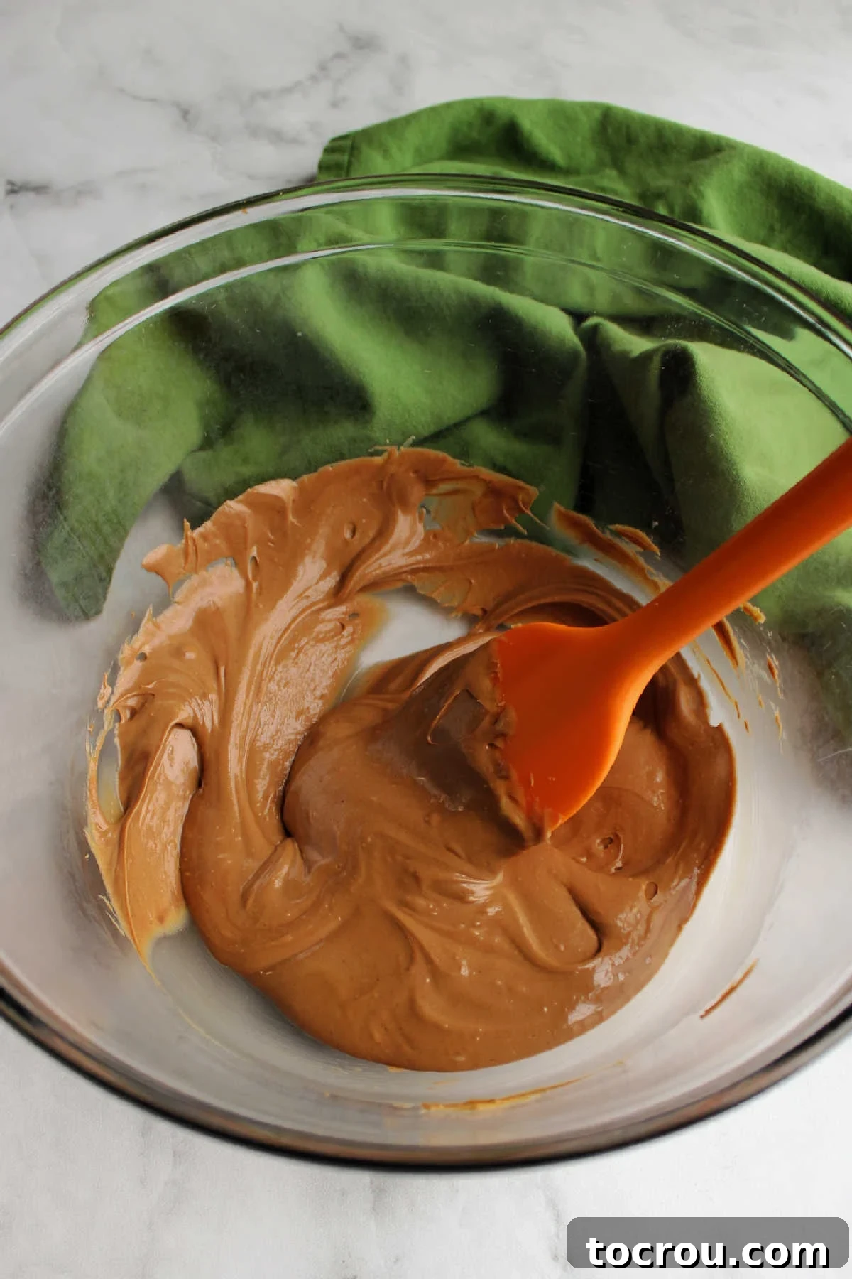 Melted Chocolate Peanut Butter Mixture Peanut butter and chocolate melted together in glass bowl, creating a smooth mixture.