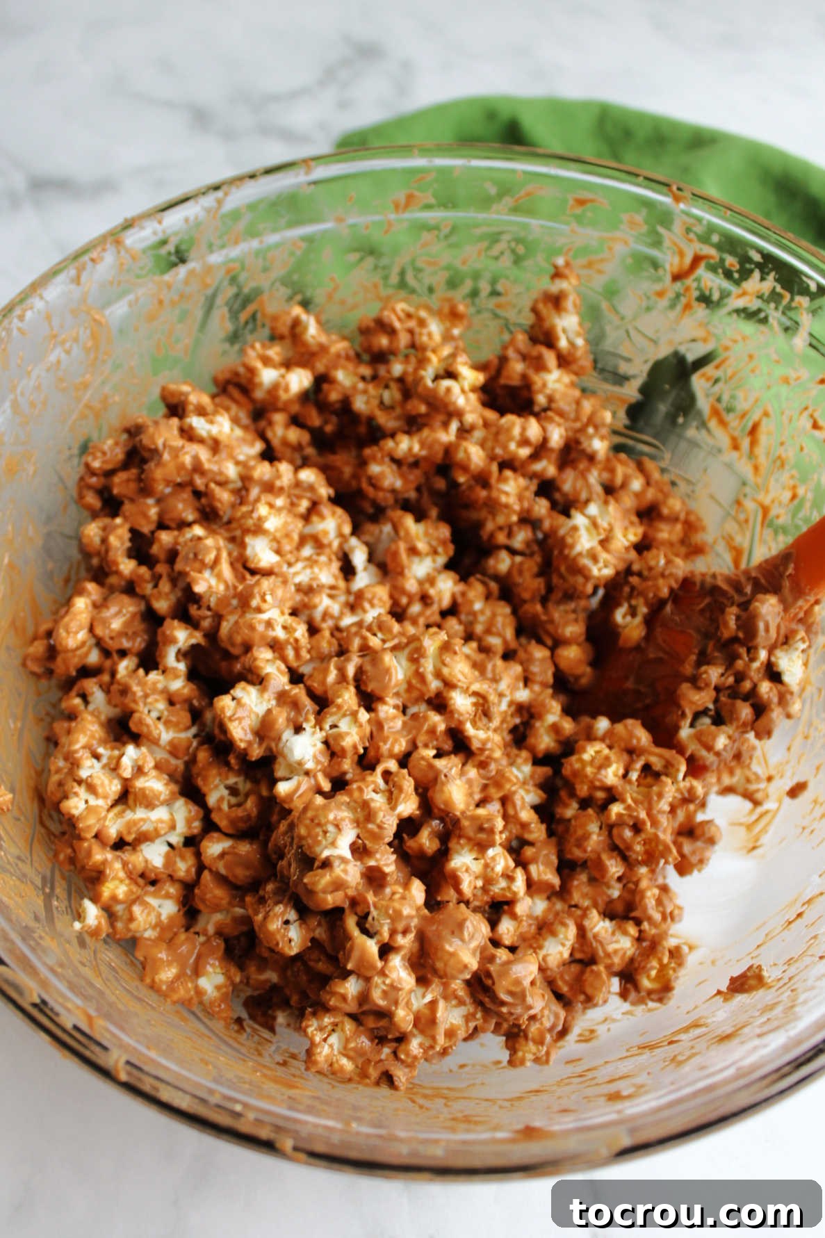 Chocolate Peanut Butter Coated Popcorn Popcorn coated in peanut butter and chocolate mixture, before powdered sugar.