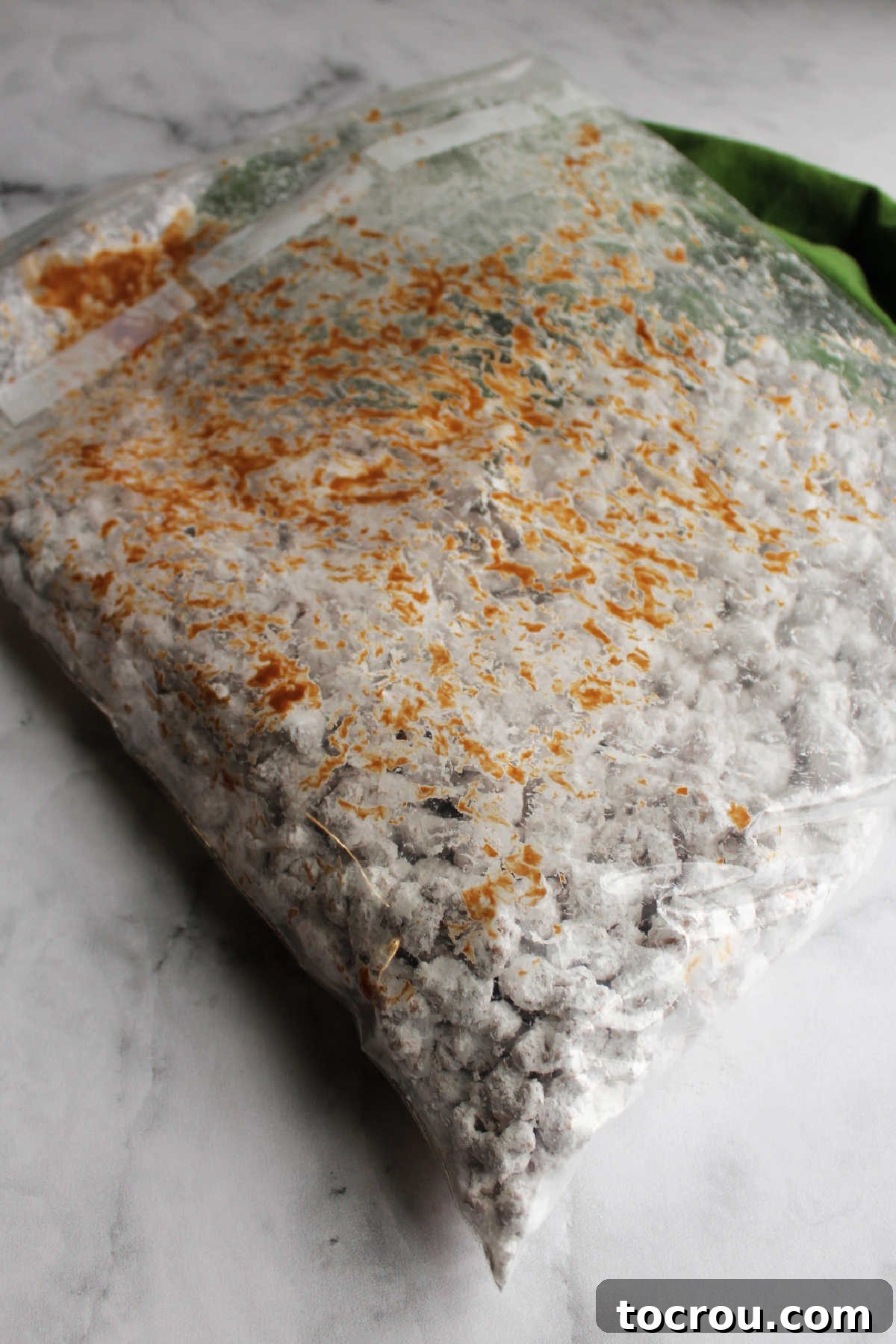 Shaking Puppy Chow Popcorn Big plastic bag with powdered sugar coated puppy chow popcorn, ready for shaking.