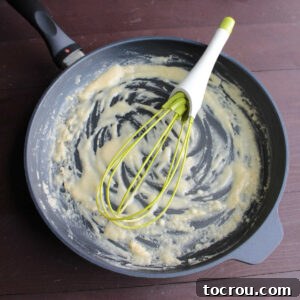 making roux with whisk in skillet.