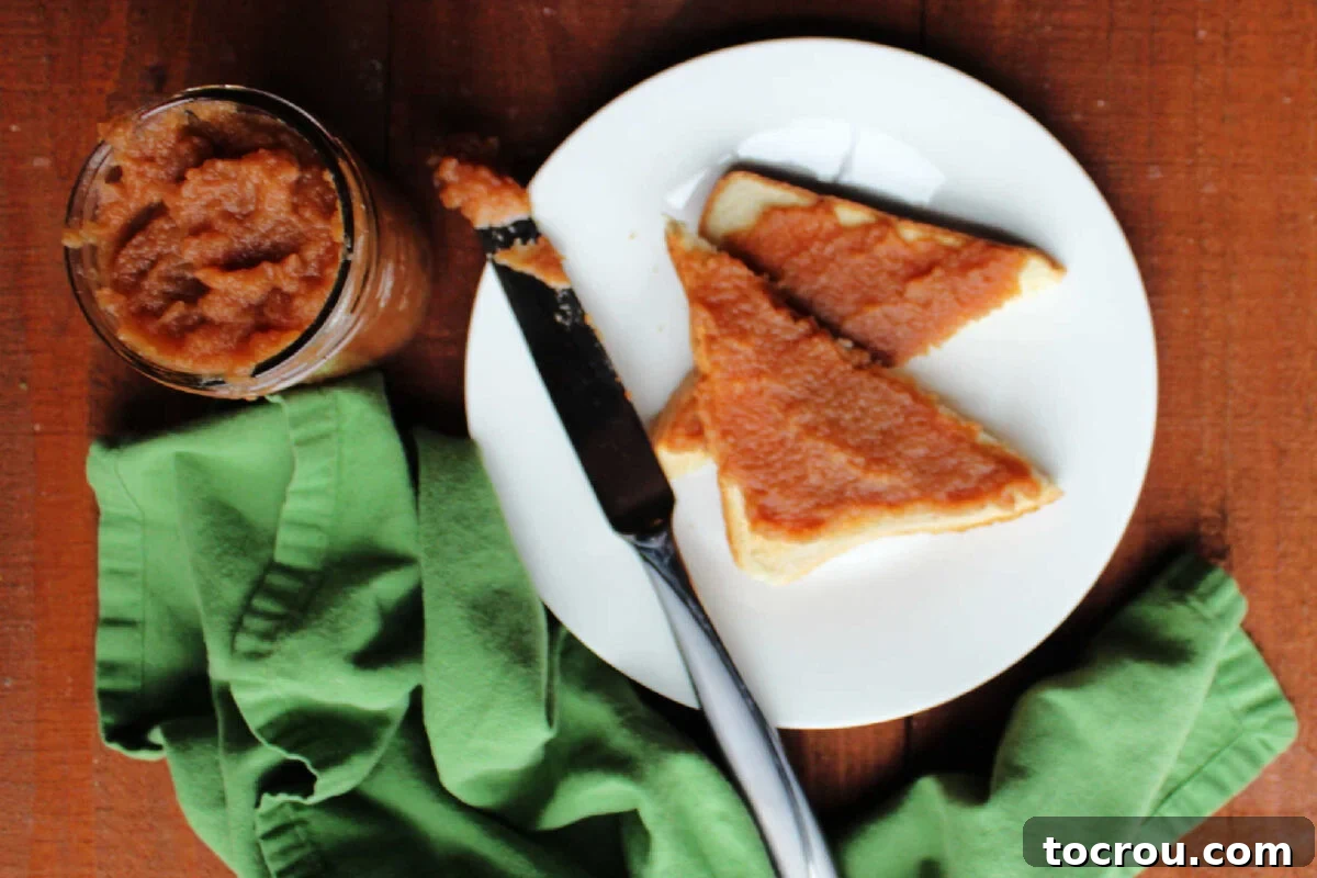 Homemade Apple Butter on Toast Apple butter spread over toast next to a jar of more homemade apple butter.